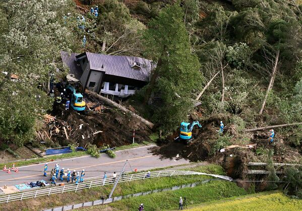 Спасатели и полиция у разрушенного дома следствие землетрясения на острове Хоккайдо, Япония - Sputnik Молдова