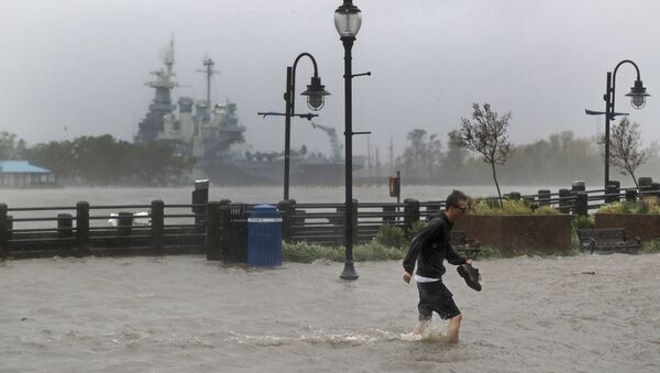 A man crosses a flooded street in downtown Wilmington, N.C., after Hurricane Florence made landfall Friday, Sept. 14, 2018. - Sputnik Moldova-România