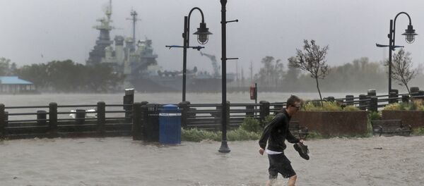 A man crosses a flooded street in downtown Wilmington, N.C., after Hurricane Florence made landfall Friday, Sept. 14, 2018. A man crosses a flooded street in downtown Wilmington, N.C., after Hurricane Florence made landfall Friday, Sept. 14, 2018. - Sputnik Moldova-România