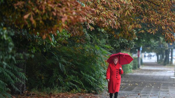 O femeie la plimbare prin ploaie - Sputnik Moldova