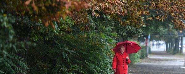 O femeie la plimbare prin ploaie - Sputnik Moldova