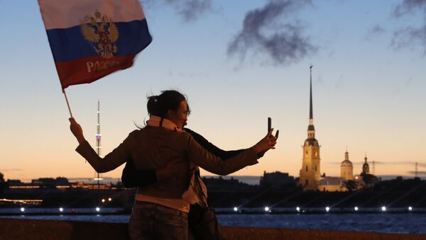 Российские болельщицы делают селфи с российским флагом в час ночи на набережной Невы в Санкт-Петербурге во время белых ночей  - Sputnik Moldova-România
