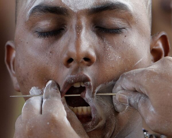 Человек с железным прутом в щеках на празднике Тайпусам в Малайзии Человек с железным прутом в щеках на празднике Тайпусам в Малайзии - Sputnik Молдова