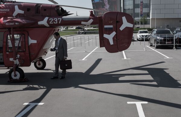 Посетитель осматривает вертолет КА-226Т на VIII Международной выставке вертолетной индустрии HeliRussia 2015 в Москве - Sputnik Молдова
