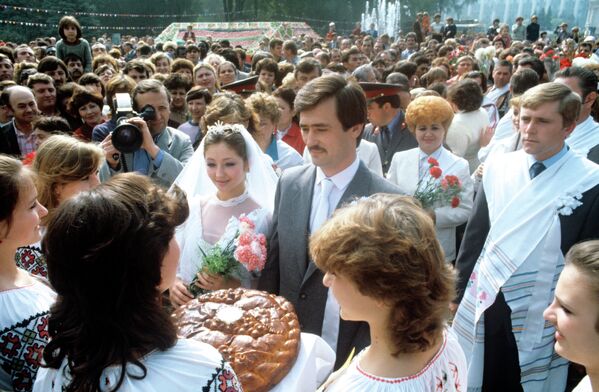 RSS Moldovenească. Tinerii însurăței Aurica Lapșina și  Victor Tomai, la sărbătoarea tradițională „Toamna de Aur”, în parcul „A. S. Pușkin”, astăzi grădina publică Ștefan cel Mare, Chișinău, 1986 - Sputnik Moldova