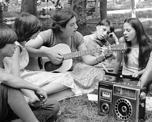 Студенты Гарвардского университета вместе с ребятами из пионерского лагеря поют песни под гитару, Молдова, 1981 год. - Sputnik Молдова