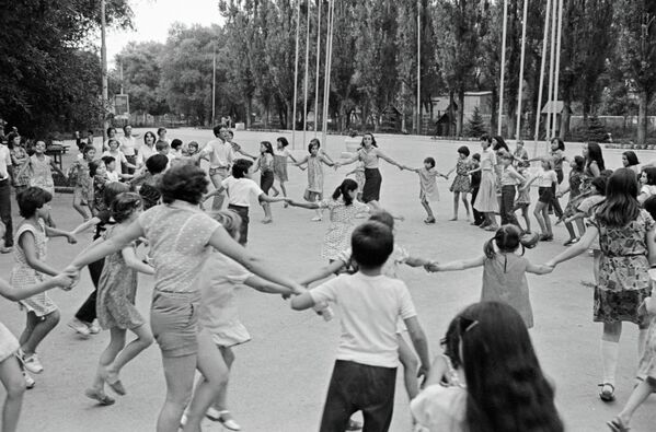 Студенты Гарвардского университета, работающие пионервожатыми в одном из пионерских лагерей, водят с детьми хоровод, Молдова, 1981 год. - Sputnik Молдова