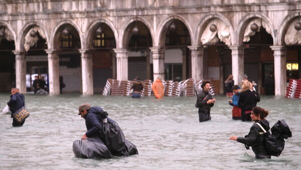 People walk in a flooded Saint Mark Square during a period of seasonal high water in Venice, Italy October 29, 2018 - Sputnik Moldova-România