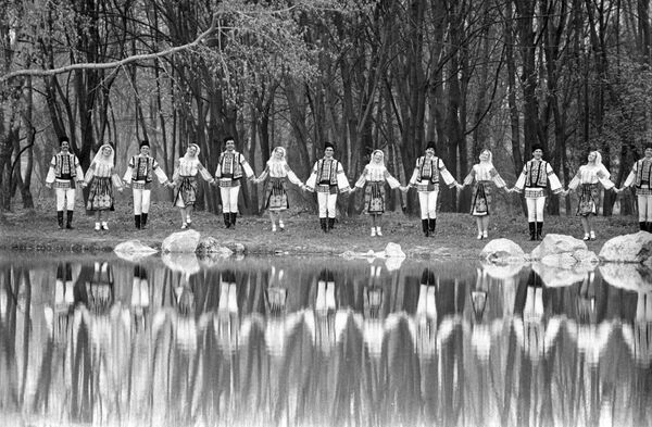 Ansamblul de muzică și dansuri populare „Arcușul” din satul Sărata Galbenă, concertează la marginea pădurii, anul 1989 - Sputnik Moldova-România