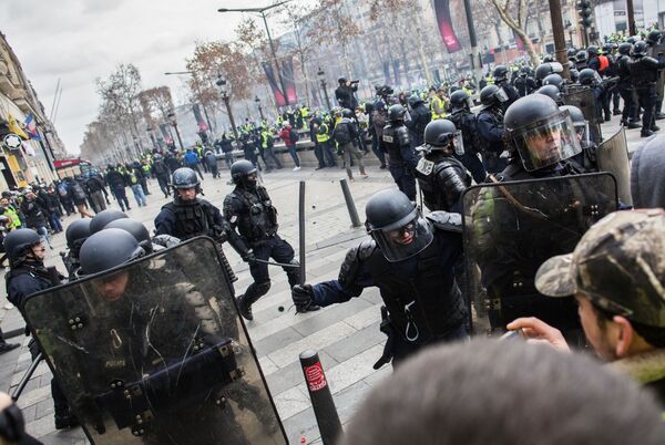 Сотрудники правоохранительных органов во время акции протеста участников движения автомобилистов желтые жилеты в районе Триумфальной арки в Париже - Sputnik Молдова