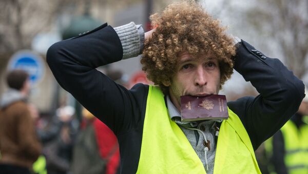 Участник акции протеста движения автомобилистов желтые жилеты в районе Триумфальной арки в Париже - Sputnik Moldova-România