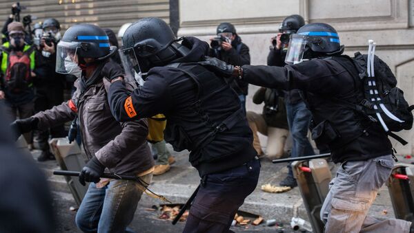 Сотрудники правоохранительных органов во время акции протеста участников движения автомобилистов желтые жилеты в районе Триумфальной арки в Париже - Sputnik Молдова