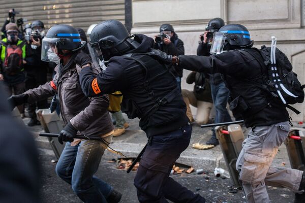 Сотрудники правоохранительных органов во время акции протеста участников движения автомобилистов желтые жилеты в районе Триумфальной арки в Париже - Sputnik Moldova