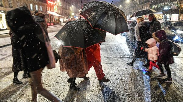 Прохожие на пешеходном переходе во время снегопада в Париже - Sputnik Moldova-România