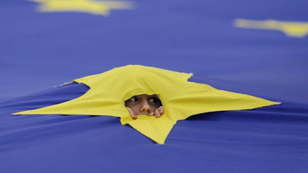 Ребенок смотрит через разрез, сделанный на одной из звезд, которые составляют флаг Европейского Союза, во время митинга поддержки, организованного в честь 60-летия Европейского Союза в Риме, в центре Бухареста, Румыния - Sputnik Moldova-România