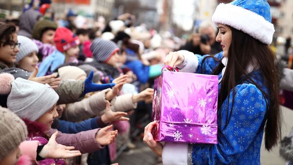 Снегурочка раздает детям подарки во время парада Дедов Морозов и Снегурочек и сказочных персонажей в Краснодаре - Sputnik Молдова