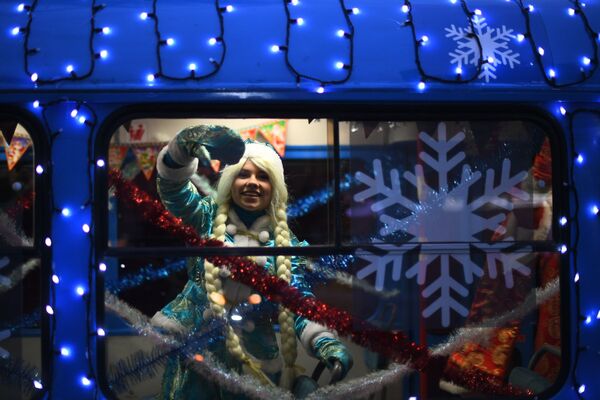 Снегурочка в салоне новогоднего трамвая, украшенный яркими светодиодными огнями, в Москве - Sputnik Молдова