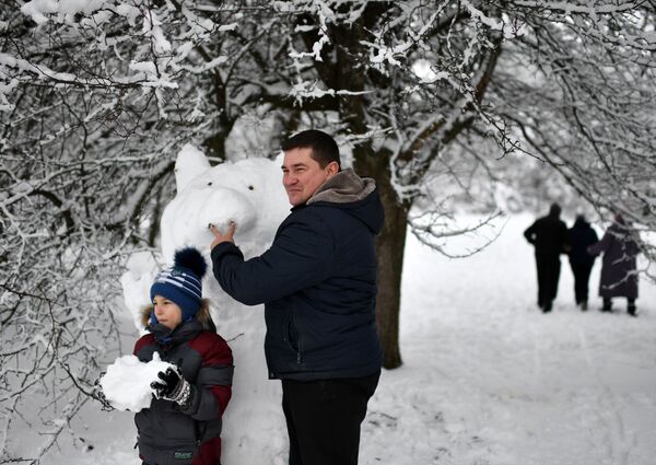 Отец с сыном лепят снеговика на Ангарском перевале в Крыму - Sputnik Молдова