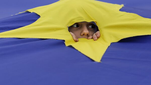 Ребенок смотрит через разрез, сделанный на одной из звезд, которые составляют флаг Европейского Союза, во время митинга поддержки, организованного в честь 60-летия Европейского Союза в Риме, в центре Бухареста, Румыния - Sputnik Moldova