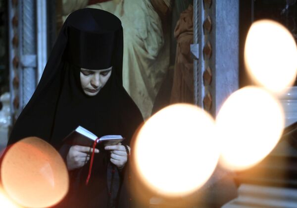 Монахиня перед Рождественским богослужением в храме Христа Спасителя в Москве - Sputnik Молдова