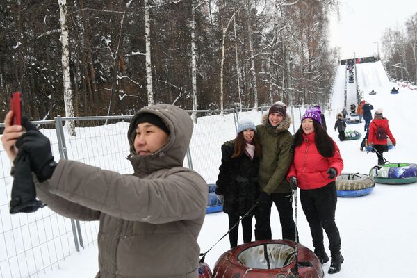 Посетители катаются на тюбингах с горки Всепогорка в парке Сокольники - Sputnik Молдова