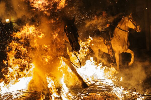 Всадники проезжают через огонь во время ежегодного фестиваля Las Luminarias в испанской деревне Сан-Бартоломе-де-Пинаре - Sputnik Молдова