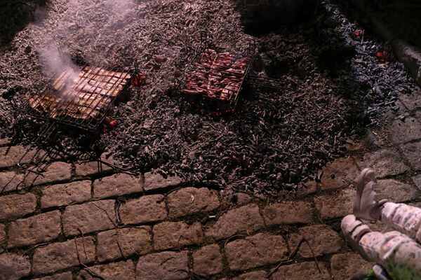 Люди во время приготовления мяса накануне фестиваля Las Luminarias в Испании  - Sputnik Молдова