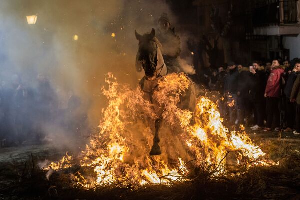 Всадник проезжает через огонь во время ежегодного фестиваля Las Luminarias в испанской деревне Сан-Бартоломе-де-Пинаре - Sputnik Moldova