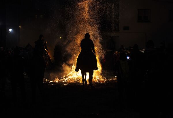 Всадник проходит через огонь во время ежегодного фестиваля Las Luminarias в испанской деревне Сан-Бартоломе-де-Пинаре - Sputnik Moldova