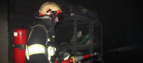 Пожарный во время тушения возгорания на автосервисе в Кишиневе - Sputnik Молдова