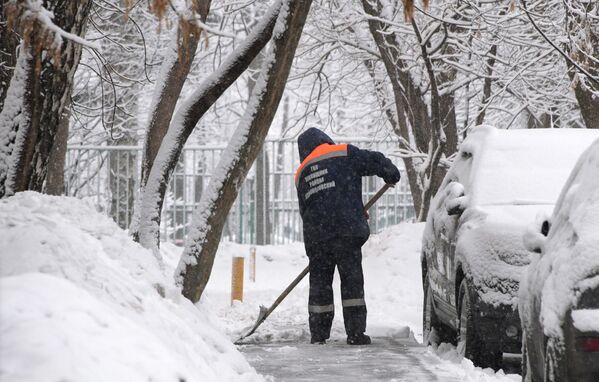 Сотрудник коммунальных служб убирает снег в Москве - Sputnik Moldova-România