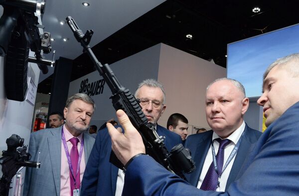 Генеральный директор АО Рособоронэкспорт Александр Михеев (второй справа) осматривает автомат Калашникова 200-й серии на международной выставке вооружений IDEX-2019 в Абу-Даби - Sputnik Moldova-România