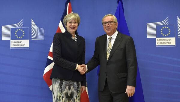 British Prime Minister Theresa May (L) shakes hands with European Commission chief Jean-Claude Juncker prior to a Brexit negotiation meeting on December 4, 2017 at the European Commission in Brussels - Sputnik Moldova-România