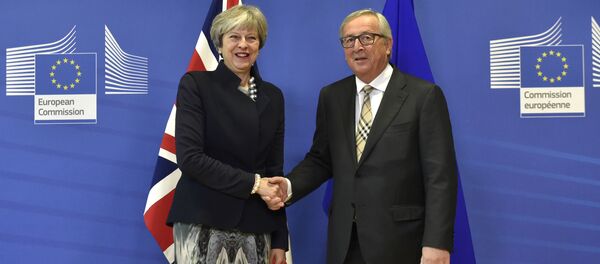 British Prime Minister Theresa May (L) shakes hands with European Commission chief Jean-Claude Juncker prior to a Brexit negotiation meeting on December 4, 2017 at the European Commission in Brussels - Sputnik Moldova-România