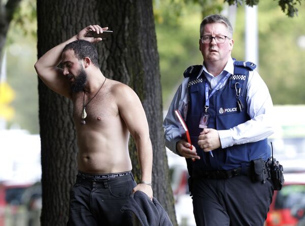Мужчина и полицейский возле мечети Ан-Нур в Крайстчерче после обстрела, Новая Зеландия - Sputnik Молдова