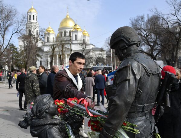 Мужчина оставляет цветы у памятника Вежливым людям во время мероприятий, посвященных 5-й годовщине Общекрымского референдума 2014 года и воссоединения Крыма с Россией, в сквере Республики в Симферополе - Sputnik Молдова