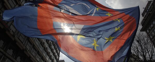 A man waves an anti NATO and EU flag during an anti NATO rally in downtown Belgrade, Serbia, March 27, 2016. - Sputnik Moldova