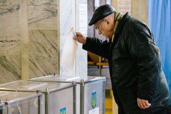 Житель Харькова на одном из избирательных участков города во время голосования на президентских выборах на Украине - Sputnik Молдова