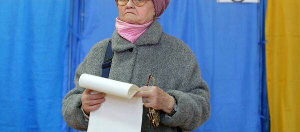 Пожилая женщина во время голосования на выборах президента Украины на одном из избирательных участков Киева - Sputnik Moldova-România