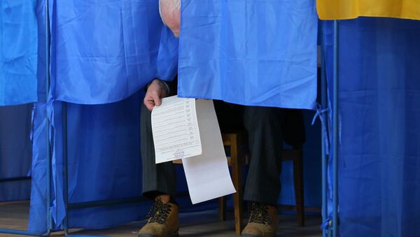 Мужчина изучает бюллетень в кабинке для голосования на президентских выборах на одном из избирательных участков Киева - Sputnik Moldova