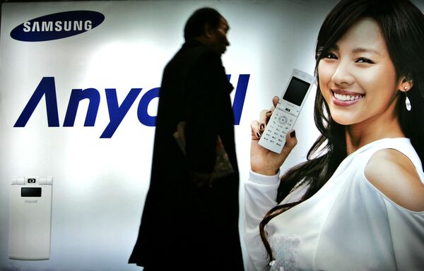 Пешеход идет мимо рекламного щита Samsung Mobile в Сеуле, Южная Корея. 2007 год - Sputnik Молдова