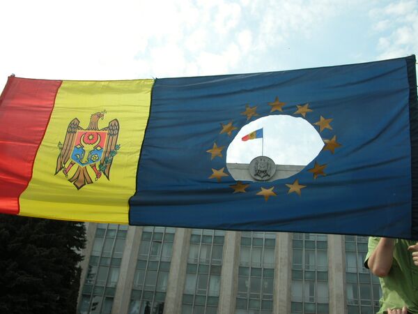 Drapelul Moldovei şi drapelul UE cu o gaură la mijloc, aşa cum arăta în vremuri trecute drapelul României la demonstraţii. - Sputnik Moldova-România