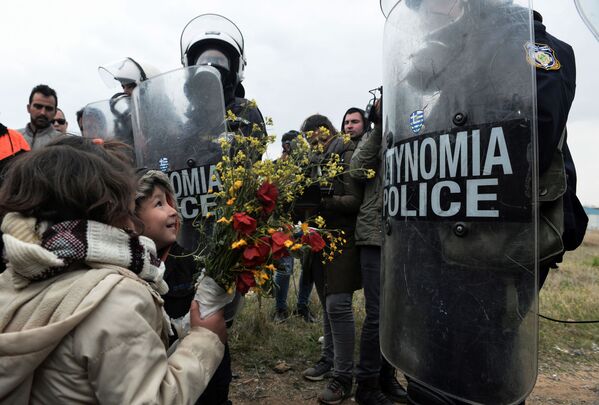 Дети дарят цветы сотрудникам греческой полиции после столкновений у лагеря беженцев в Диавате, Греция - Sputnik Moldova-România