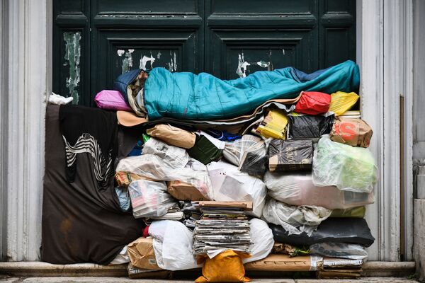 Бездомный спит на куче мусора под крыльцом в Риме, Италия - Sputnik Moldova-România