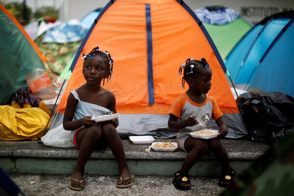 Девочки из Конго едят возле своей палатки в импровизированном лагере рядом с Национальным институтом миграции (INM) в Тапачуле, Мексика - Sputnik Moldova-România