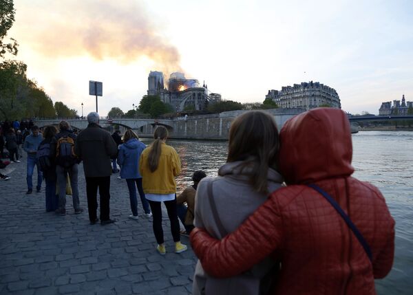 Люди смотрят, как горит собор Парижской Богоматери - Sputnik Молдова