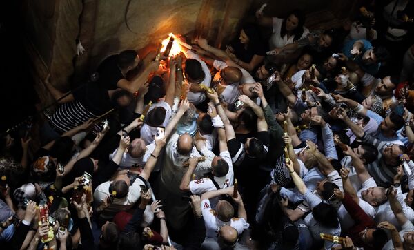 Верующие празднуют схождение Благодатного огня в храме Гроба Господня в Иерусалиме - Sputnik Молдова