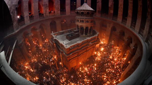 Верующие празднуют схождение Благодатного огня в храме Гроба Господня В Иерусалиме - Sputnik Молдова