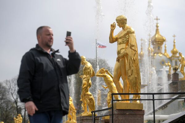 Турист фотографирует у фонтанов Большого каскада во время весеннего открытия в Государственном музее-заповеднике Петергоф - Sputnik Молдова