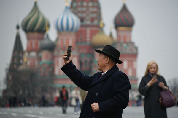 Турист фотографируется на Красной площади в Москве, на фоне храма Василия Блаженного - Sputnik Молдова